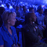 a group of people sitting next to each other in front of a crowd