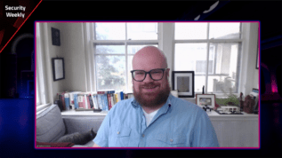 a man with glasses and a blue shirt